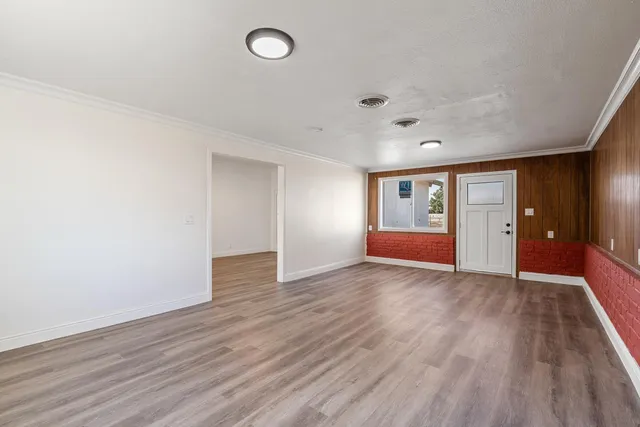 an empty room with wooden floor and window