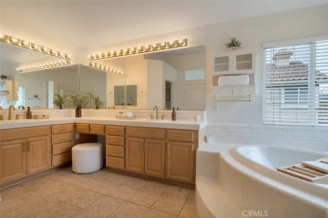 a spacious bathroom with a double vanity sink a mirror and bathtub