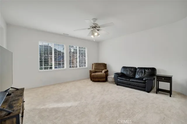 a living room with furniture ceiling fan and a window