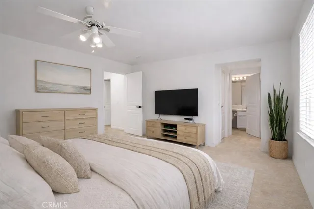 a bedroom with a bed a television and a couch