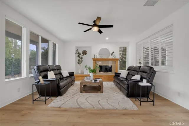 a living room with furniture a fireplace and a large window