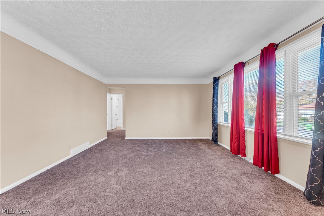 9716 Alexander Road Cleveland, OH 44125 - Photo 3 of 30 Empty room featuring carpet flooring and a textured ceiling