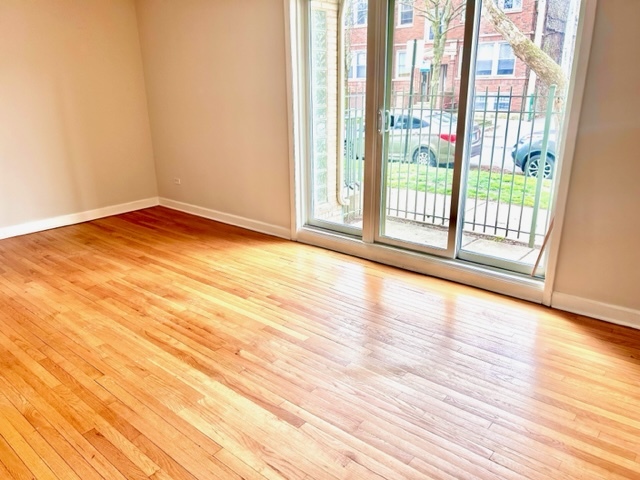 1246 West Byron Street, Unit 1 Chicago, IL 60613 - Photo 4 of 7 a view of empty room with wooden floor and fan