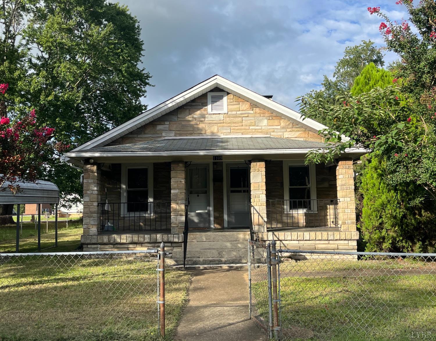 1109 Amherst Avenue Altavista, VA 24517 - Photo 1 of 23 a view of a house with small yard plants and palm trees