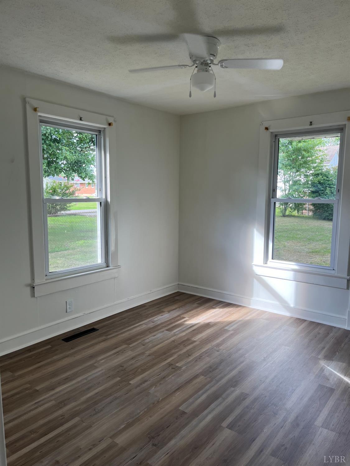 1109 Amherst Avenue Altavista, VA 24517 - Photo 10 of 23 a view of an empty room with wooden floor and a window