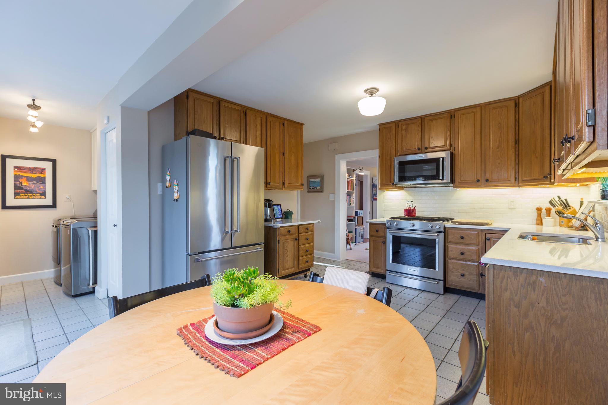 1405 Ridge Road Baltimore, MD 21228 - Photo 12 of 30 a kitchen with stainless steel appliances granite countertop a refrigerator a stove top oven a sink dishwasher and wooden floor