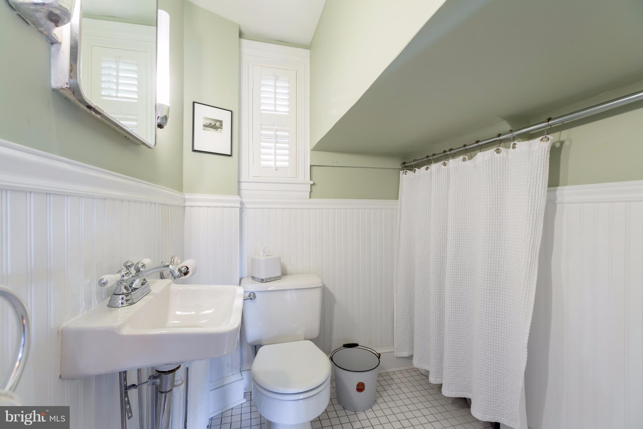 1405 Ridge Road Baltimore, MD 21228 - Photo 14 of 30 a bathroom with a sink a toilet and a mirror