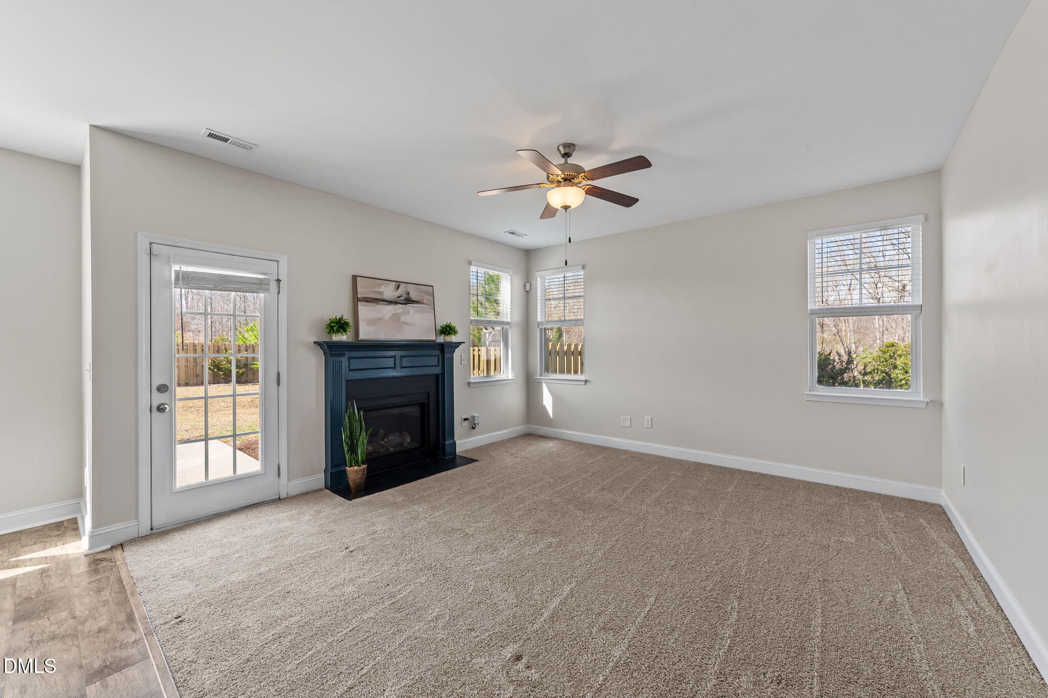 41 Solstice Lane Garner, NC 27529 - Photo 11 of 33 a view of a livingroom with a fireplace a ceiling fan and windows