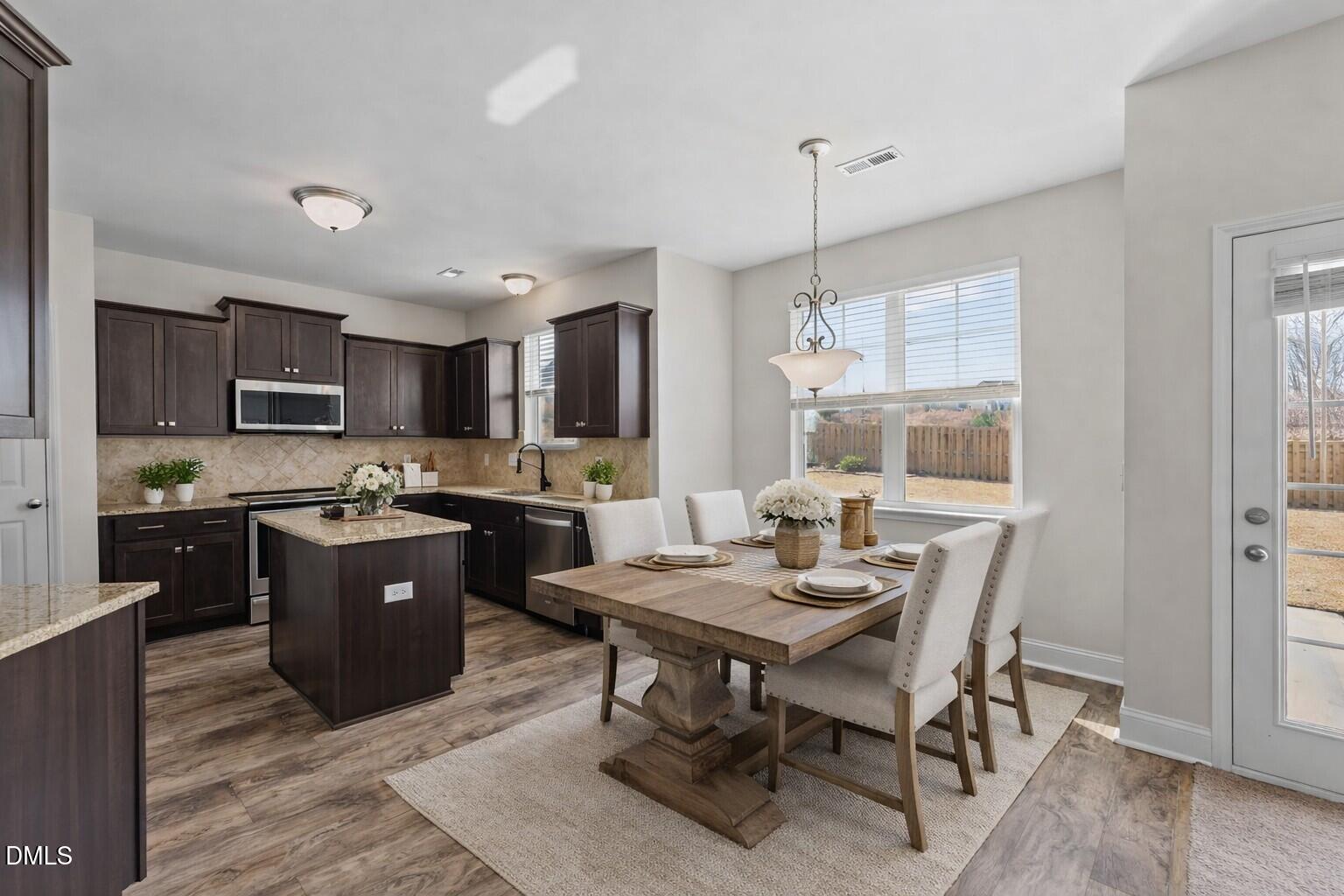 41 Solstice Lane Garner, NC 27529 - Photo 8 of 33 a kitchen with a table chairs refrigerator and microwave