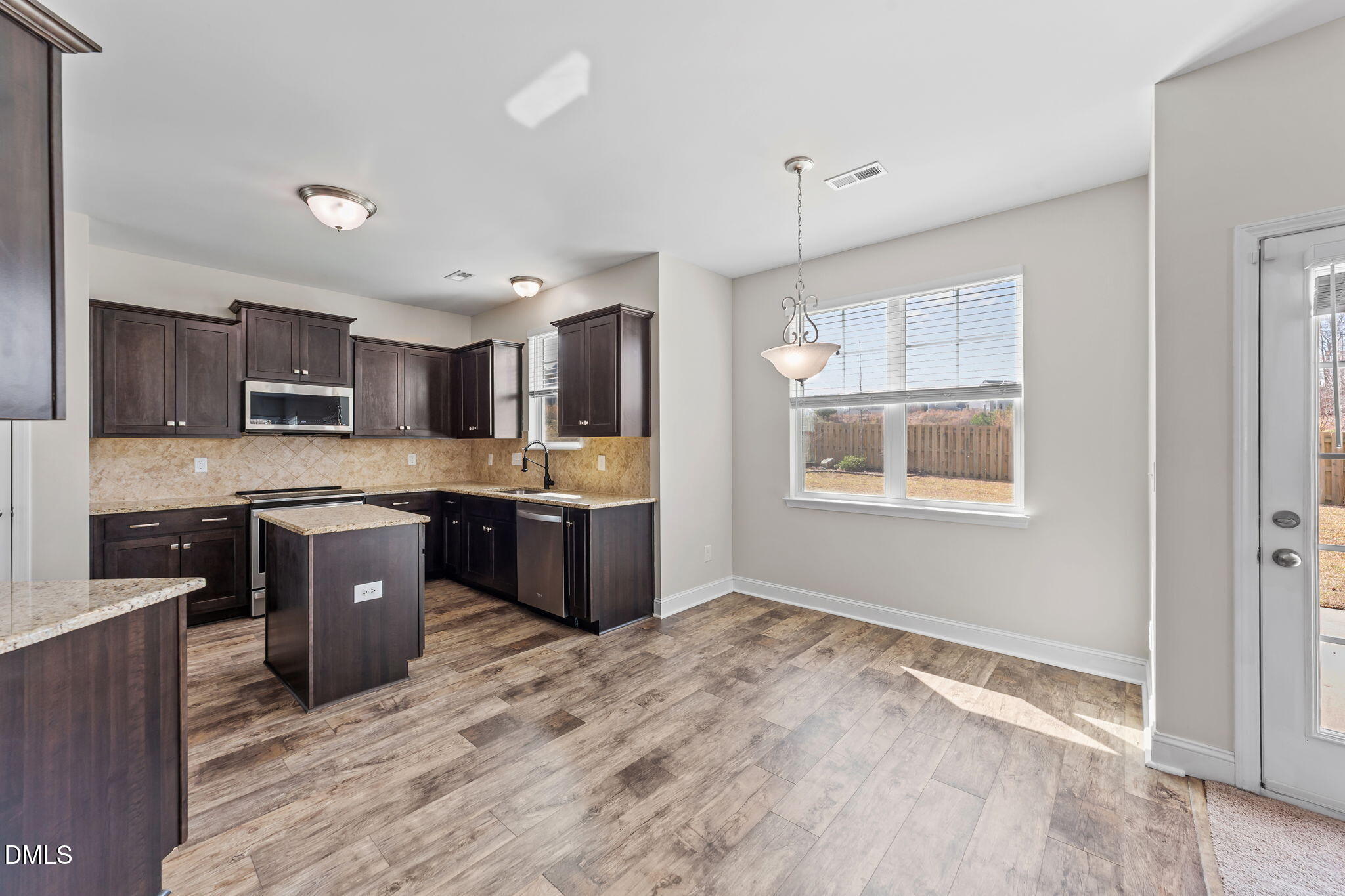41 Solstice Lane Garner, NC 27529 - Photo 9 of 33 a kitchen with stainless steel appliances kitchen island granite countertop a stove sink and cabinets