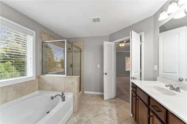 a bathroom with a tub sink and mirror