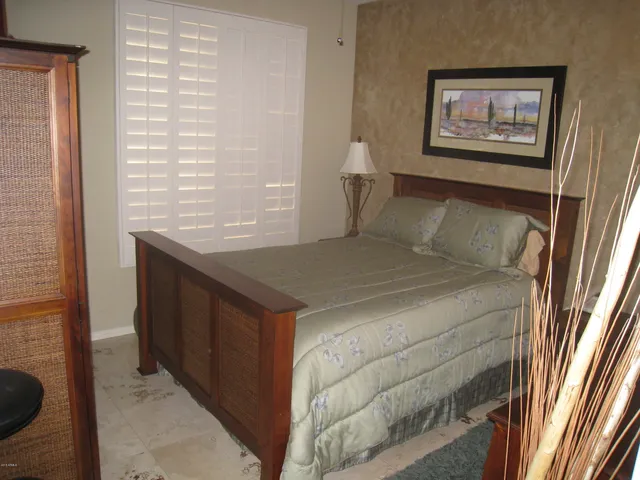 a bedroom with a bed and a painting on the wall