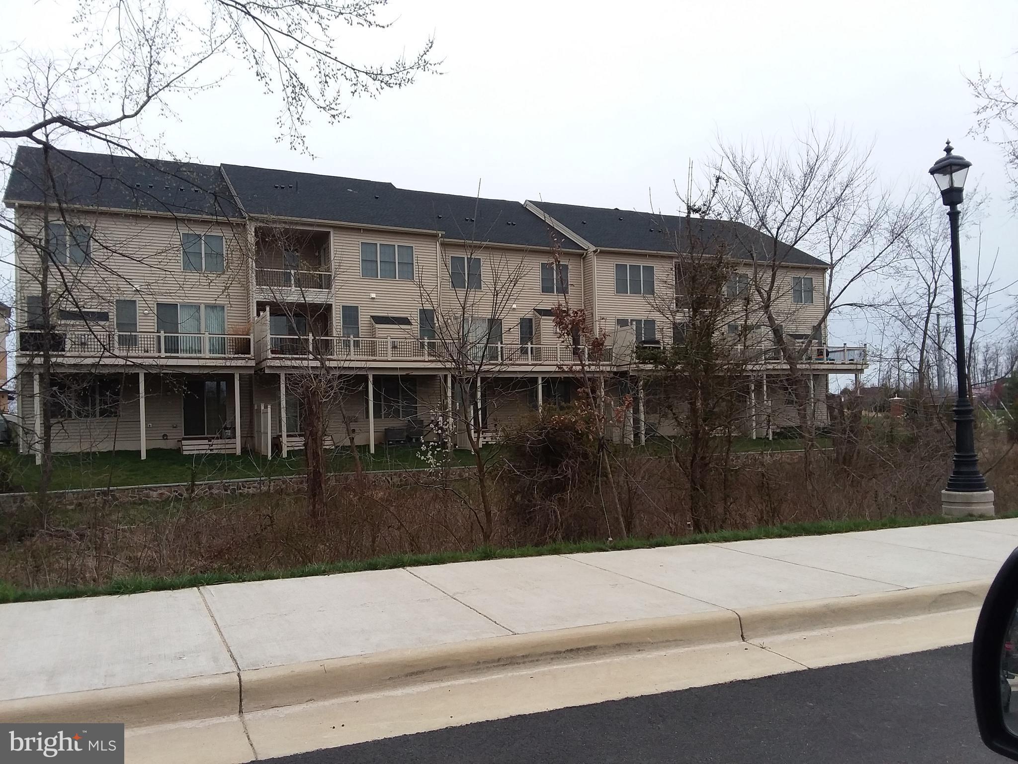 22595 Windsor Locks Square Ashburn, VA 20148 - Photo 25 of 56 a front view of a house with a yard