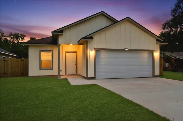 a front view of house with yard and garage
