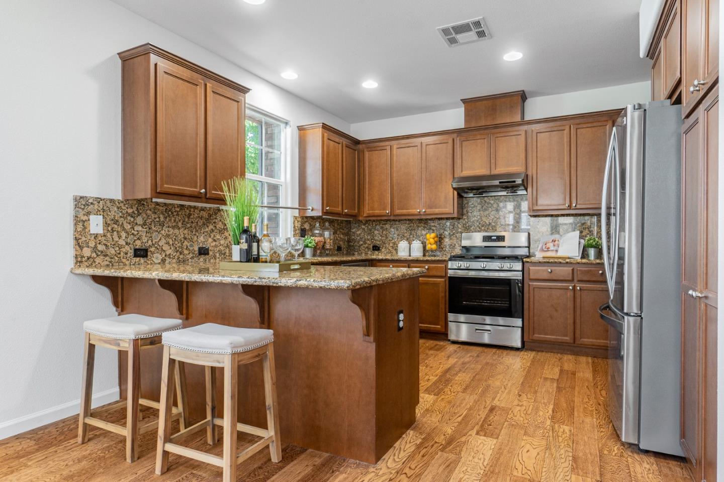 4232 Astor Hollow Street San Ramon, CA 94582 - Photo 10 of 37 a kitchen with kitchen island granite countertop wooden floors and stainless steel appliances