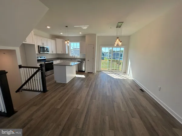 a kitchen with kitchen island granite countertop a sink a counter top space stainless steel appliances and cabinets
