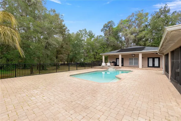 an aerial view of residential house with outdoor space and trees all around