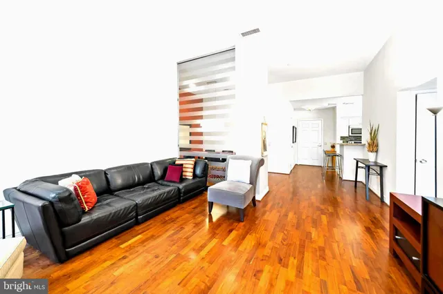 a living room with furniture and a wooden floor