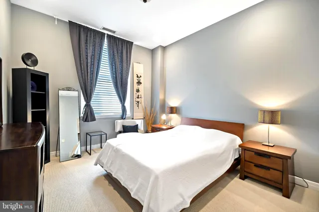 a bedroom with a bed and a dresser with mirror