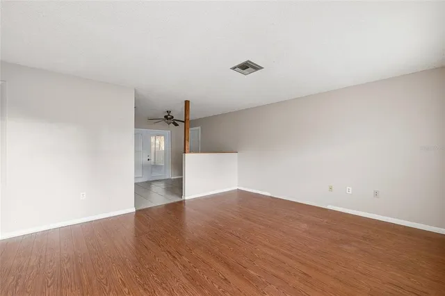 a view of empty room with wooden floor