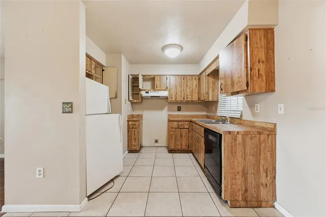 a kitchen with a refrigerator a stove top oven and cabinets