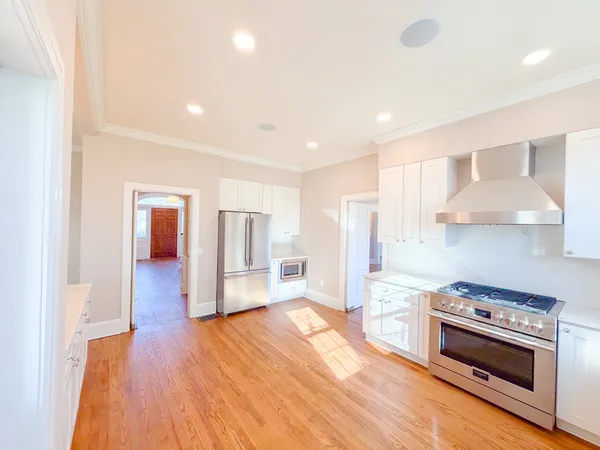 a kitchen with stainless steel appliances granite countertop a refrigerator a sink a stove top oven a counter space and cabinets