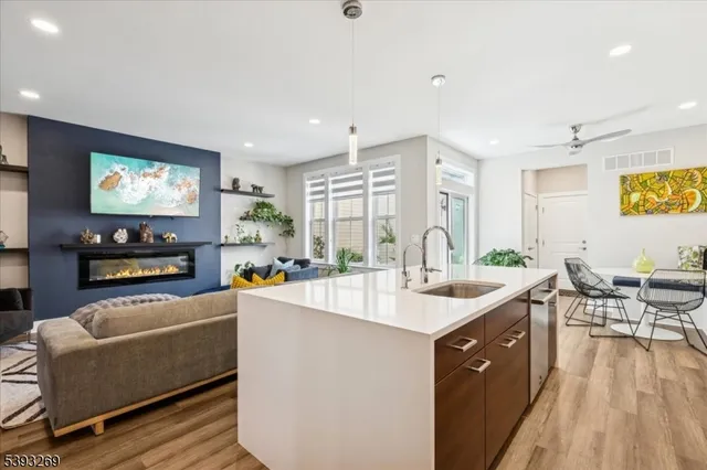 a kitchen with stainless steel appliances kitchen island granite countertop a sink and a refrigerator