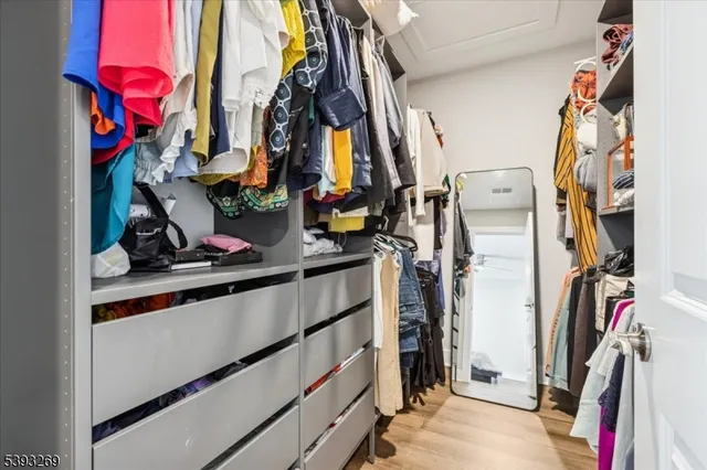a view of walk in closet with clothes and shoes