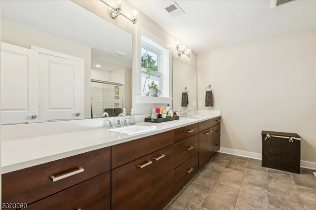 a spacious bathroom with a double vanity sink a mirror and a