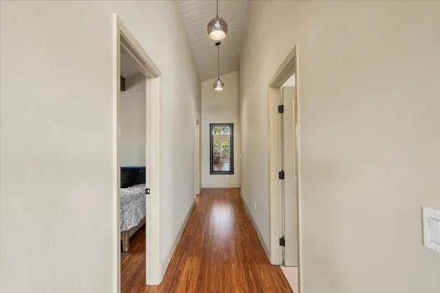 a view of a hallway with wooden floor and staircase