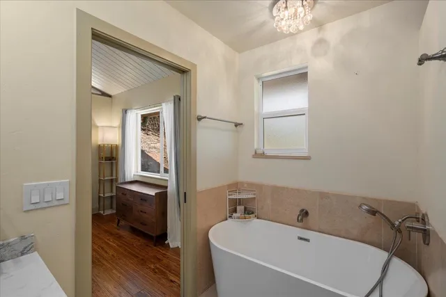 a bathroom with a tub and a view of bathroom