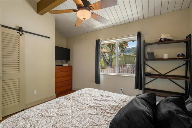 a bedroom with a bed and a flat screen tv