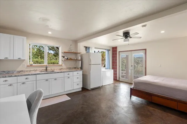 a kitchen with granite countertop white cabinets and white appliances