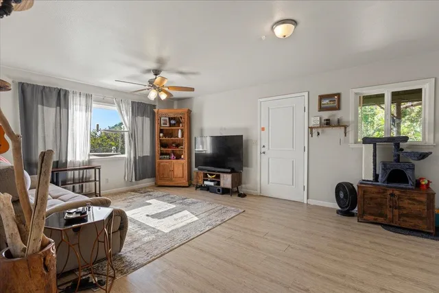 a kitchen with stainless steel appliances white cabinets a sink a stove a refrigerator and island with wooden floor