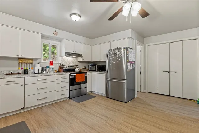 a bed sitting in a bedroom next to a window and a flat tv screen