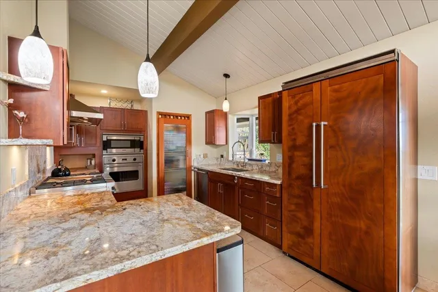 a kitchen with stainless steel appliances granite countertop sink refrigerator and stove