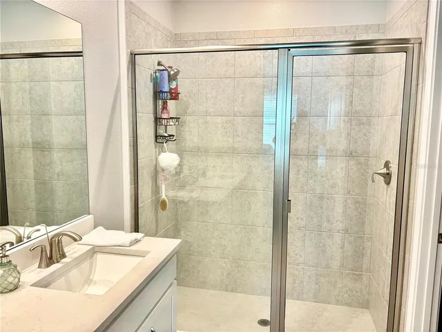 a bathroom with a granite countertop shower and a sink