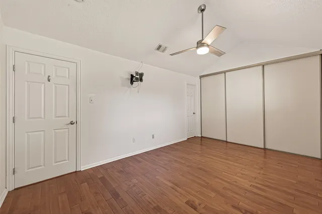 a view of an empty room with wooden floor