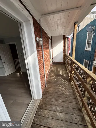 a view of balcony with wooden floor and fence