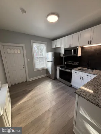 a kitchen with a sink a stove and cabinets