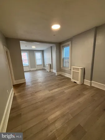 a view of a livingroom with wooden floor and a window