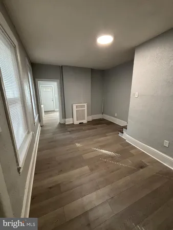a view of a livingroom with wooden floor and stairs