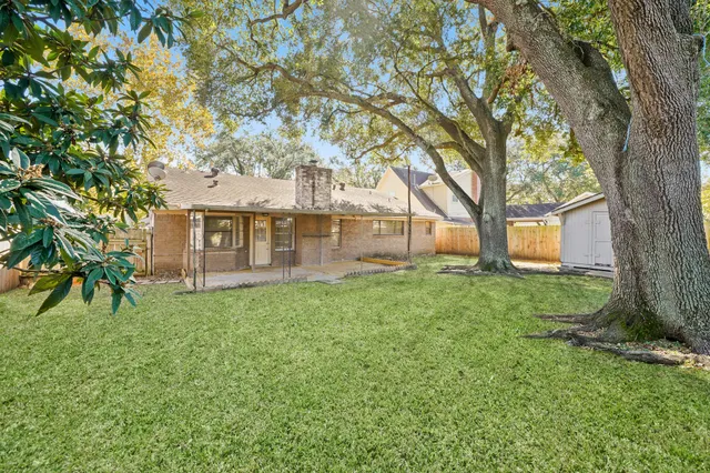 a view of a house with backyard and a tree