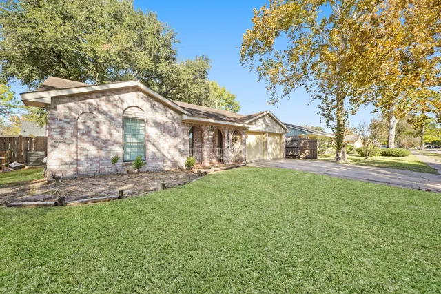 a view of a house with backyard and a tree