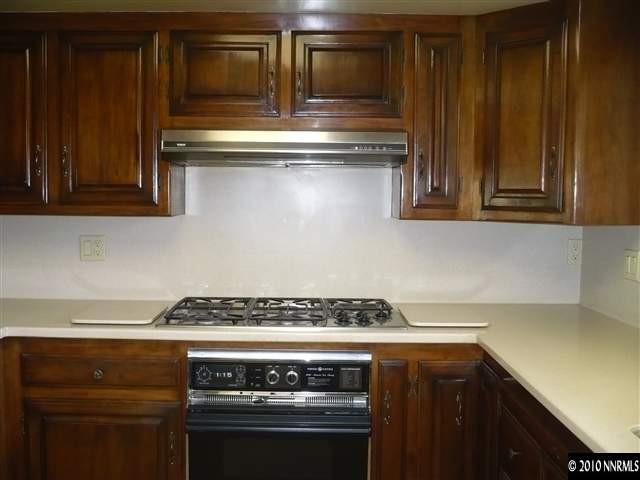 1840 Wendy Way Reno, NV 89509 - Photo 6 of 13 a stove top oven sitting inside of a kitchen and wooden cabinets