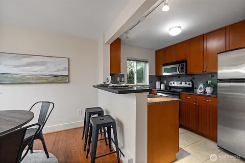 a kitchen with stainless steel appliances granite countertop a stove a sink and a microwave