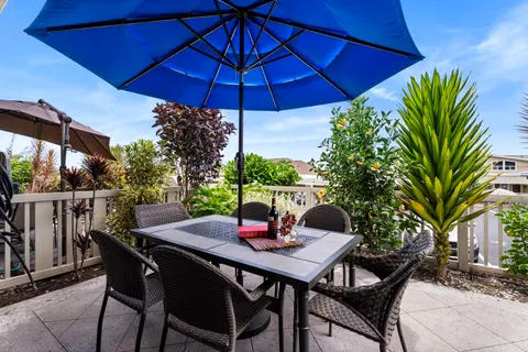 a table and chairs with the umbrella in patio