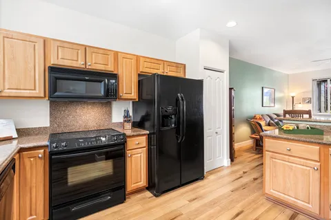 a kitchen with stainless steel appliances kitchen island granite countertop a stove refrigerator and microwave