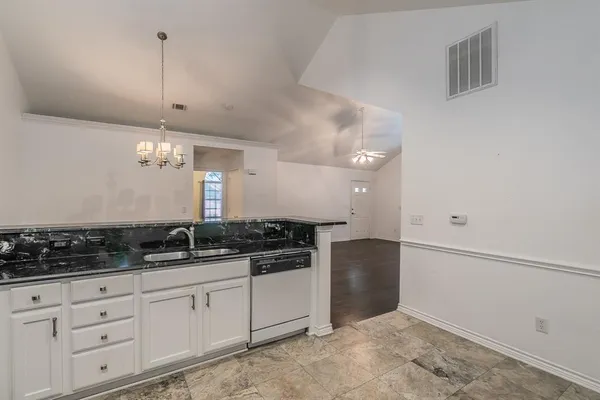 a kitchen with granite countertop a sink and cabinets
