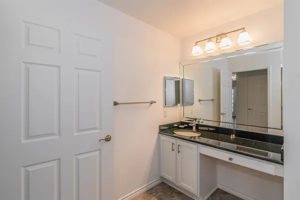 a bathroom with a granite countertop sink and a mirror